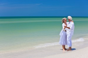 Happy Senior Couple Dancing Holding Hands on Tropical Beach